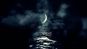magical-crescent-moon-above-the-sea-reflecting-on-water-on-a-cloudy-starry-night_ekhi4vlog__M0000